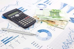 Een rekenmachine en eurobiljetten op een witte achtergrond voor de berekening van de cashflow.